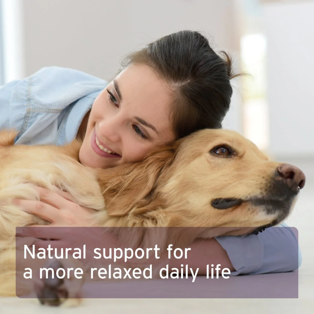 Human hugging a retriever dog with text overlay "natural support for a more relaxed daily life".