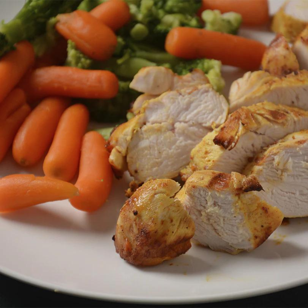 A plate with chicken, carrot and broccoli on it.