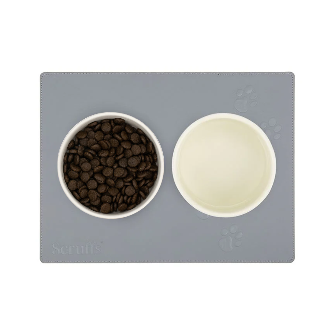 Bowls of pet food and water on a Scruffs grey faux leather place mat.