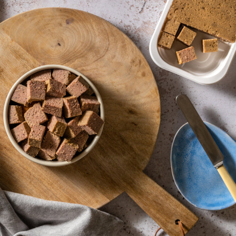 Bowl of Forthglade complimentary wet food on a wooden chopping board.