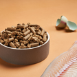 A bowl of DARF North Sea Cold Pressed dog food beside an egg shell and white fish.