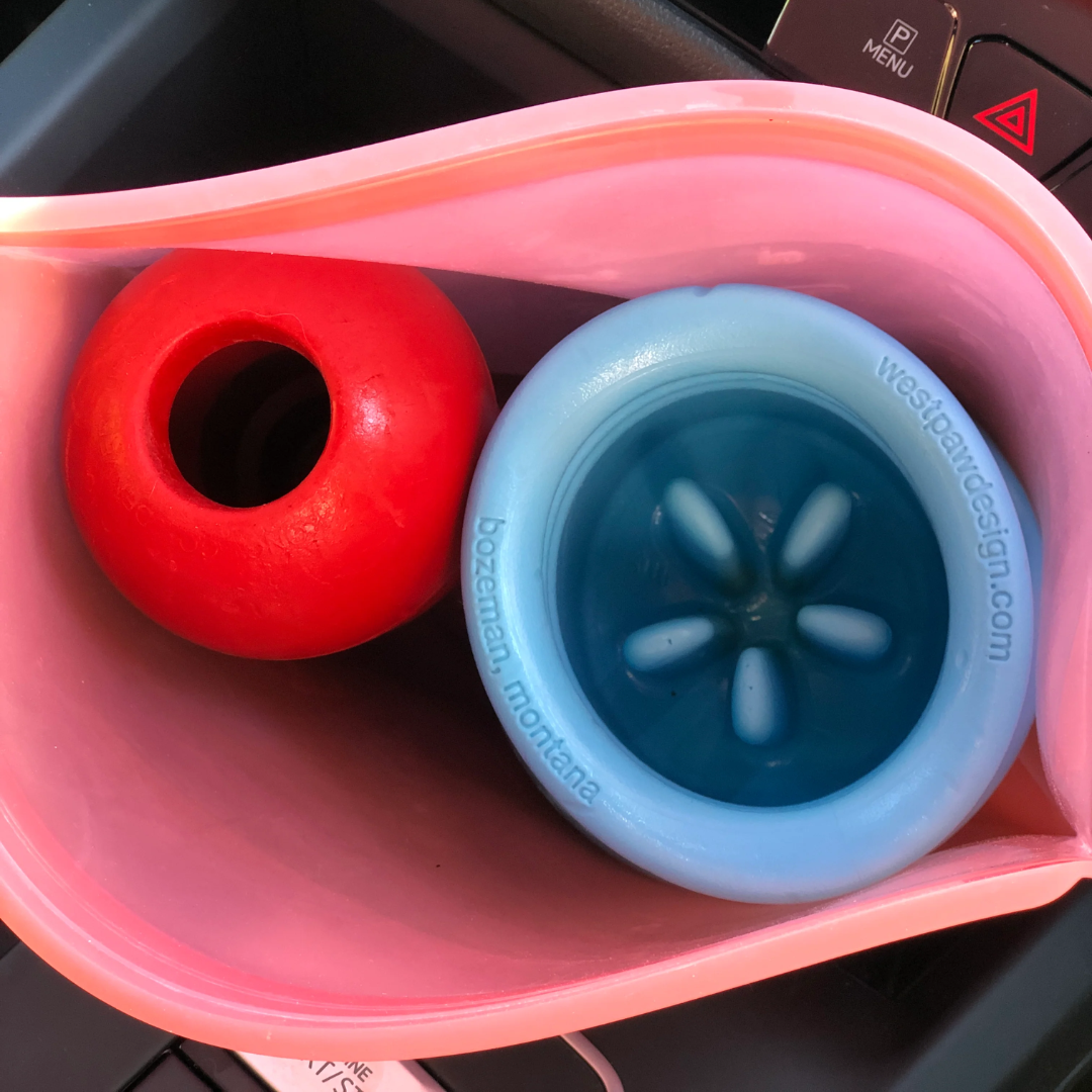 Looking inside of a Prep 'n Go bag with a west paw toy and a kong toy inside of it.