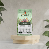 A bag of Ydolo duck semi moist cold pressed dog food on a wooden platform.